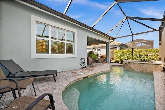 view of swimming pool featuring glass enclosure and a patio area