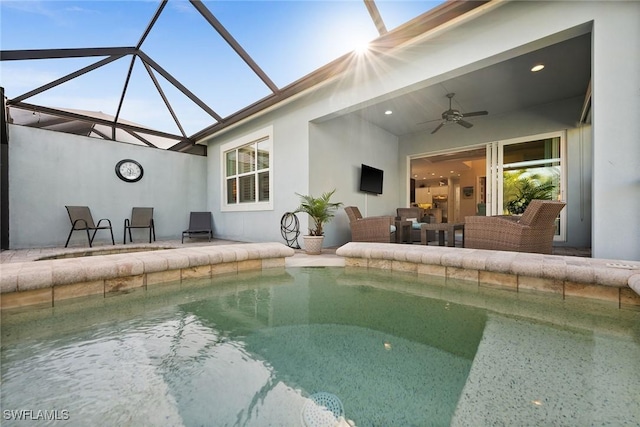 view of swimming pool with ceiling fan, an outdoor living space, a patio area, and glass enclosure