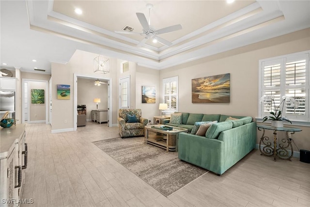 living room featuring a raised ceiling and light hardwood / wood-style flooring