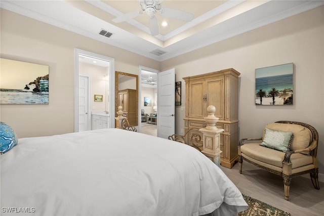 bedroom with ceiling fan, a tray ceiling, connected bathroom, and ornamental molding