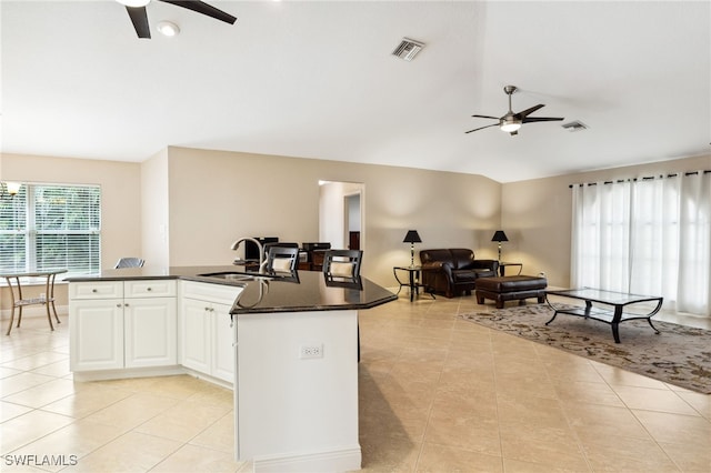 kitchen featuring ceiling fan, white cabinets, sink, and light tile patterned floors