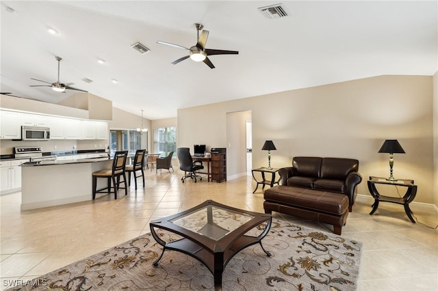 tiled living room featuring ceiling fan with notable chandelier and high vaulted ceiling