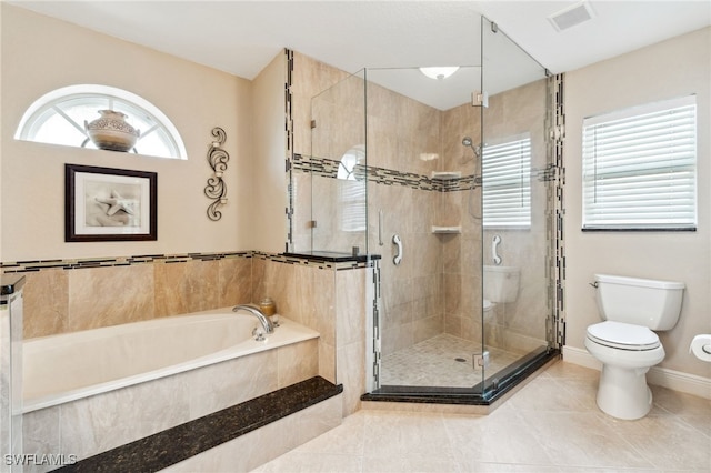 bathroom featuring toilet, tile patterned flooring, and separate shower and tub