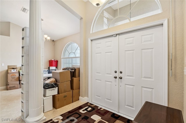 tiled entryway with an inviting chandelier