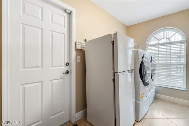 clothes washing area with light tile patterned flooring and washer / clothes dryer