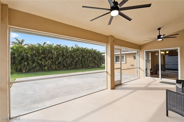 unfurnished sunroom with ceiling fan with notable chandelier and lofted ceiling