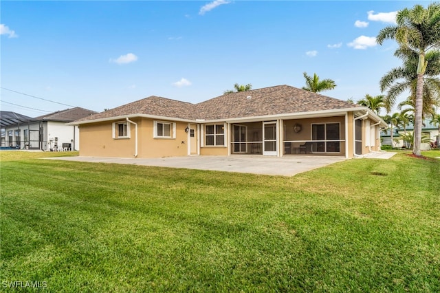 back of property with a yard, a patio, and a sunroom