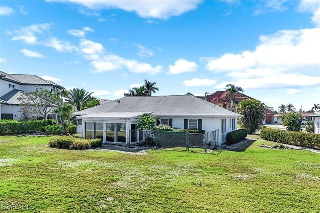 980 Iris Ct, Marco Island, FL 34145 - rear view of property featuring a lawn, fence, and a sunroom