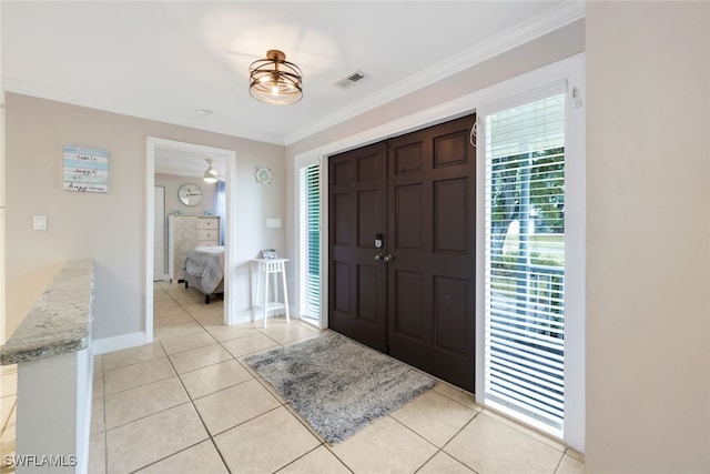 foyer entrance with light tile patterned flooring and crown molding