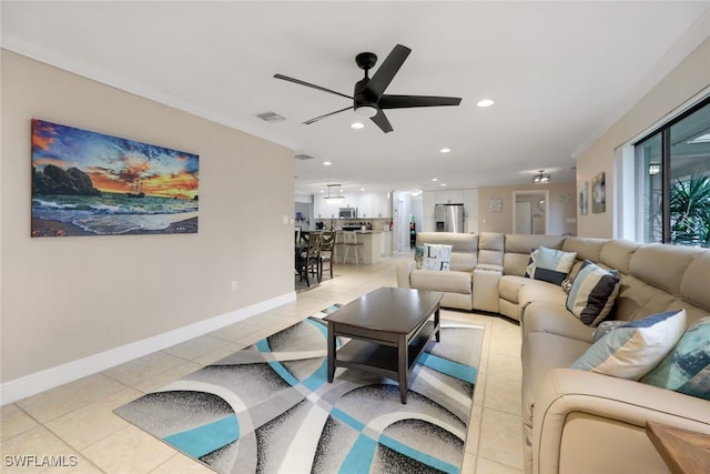 living room with crown molding, ceiling fan, and light tile patterned floors