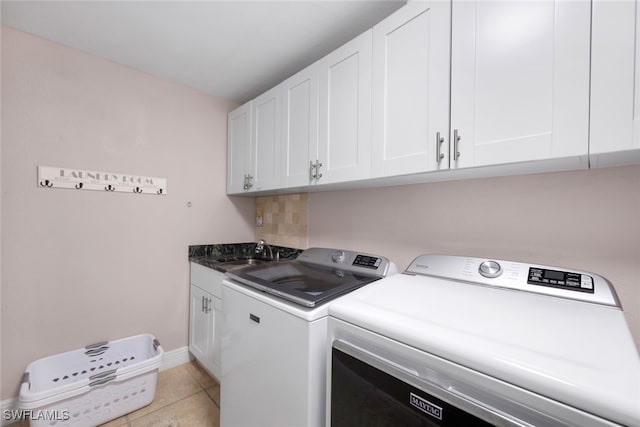 washroom featuring light tile patterned flooring, cabinets, separate washer and dryer, and sink