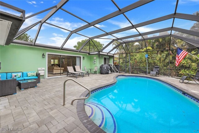 view of pool featuring a lanai, outdoor lounge area, and a patio area