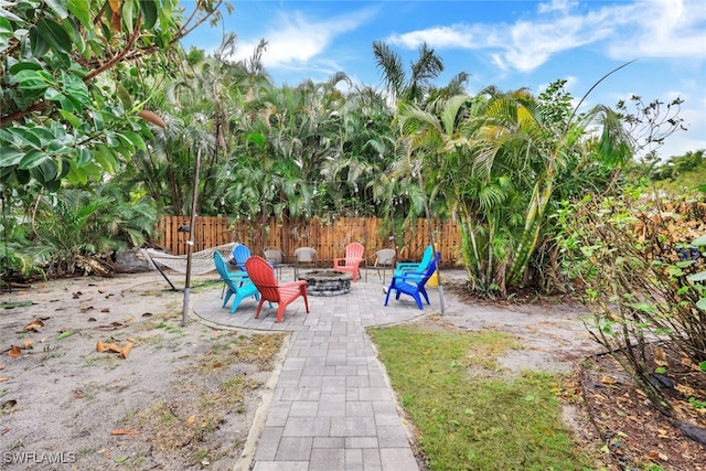 view of playground featuring an outdoor fire pit and a patio area