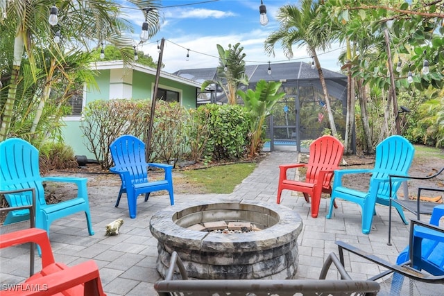 view of patio / terrace featuring glass enclosure and an outdoor fire pit