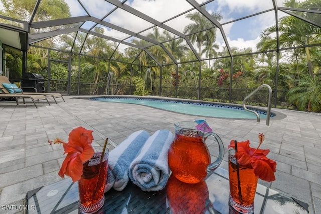 view of swimming pool featuring grilling area, a patio area, and glass enclosure