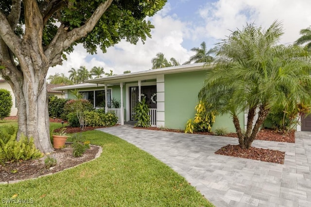 single story home with a front yard and covered porch