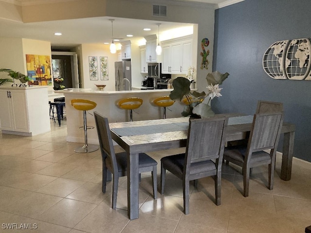 dining area featuring light tile patterned floors and crown molding