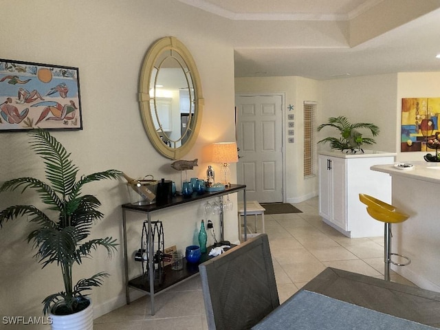 interior space with crown molding and light tile patterned floors