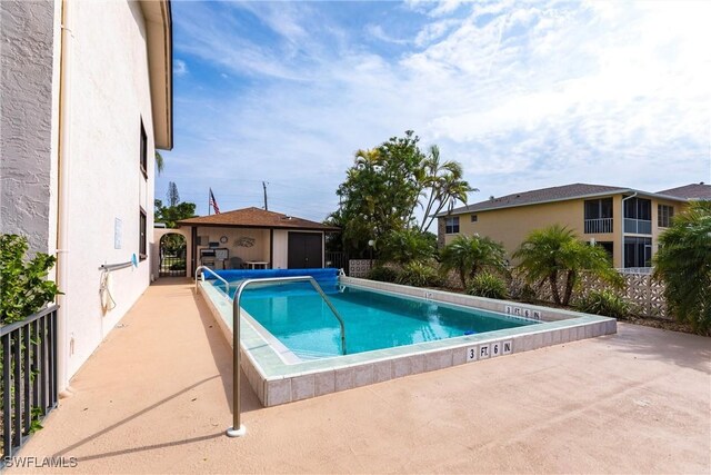 view of swimming pool with an outbuilding and a patio