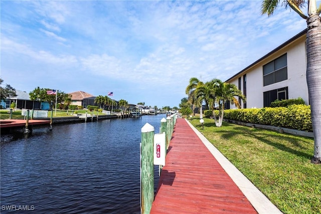 view of dock featuring a water view and a lawn