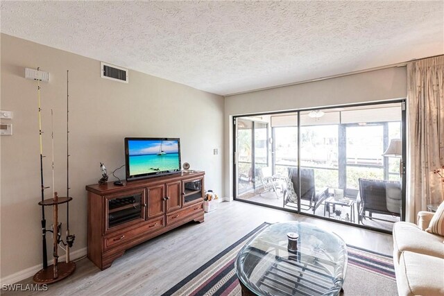 living room featuring a textured ceiling and light wood-type flooring