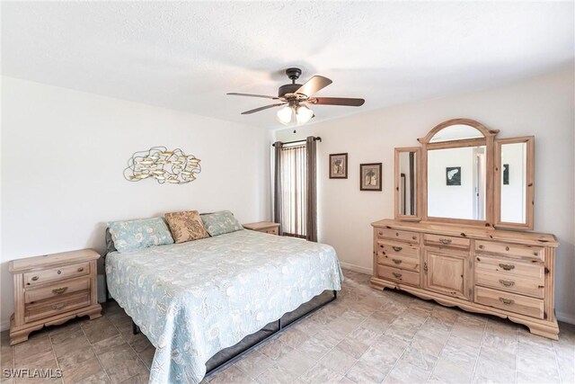 bedroom featuring ceiling fan and a textured ceiling