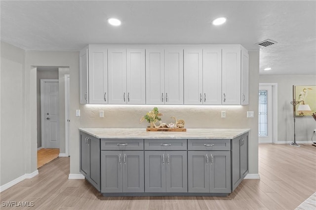 kitchen with light hardwood / wood-style floors, white cabinetry, and gray cabinetry