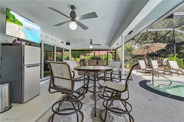 view of patio featuring ceiling fan and glass enclosure