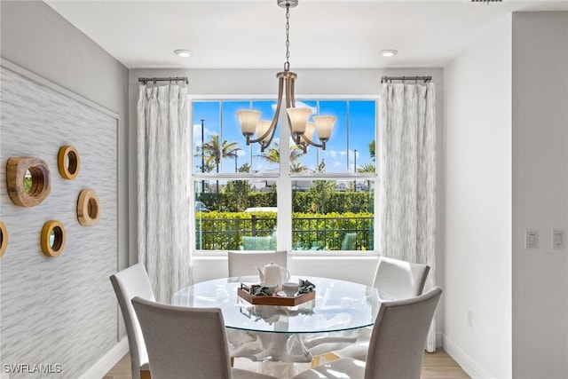 dining room with hardwood / wood-style flooring and a notable chandelier