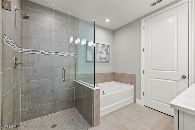 bathroom with tile patterned flooring, separate shower and tub, and vanity