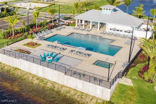 view of swimming pool with a patio area and a water view