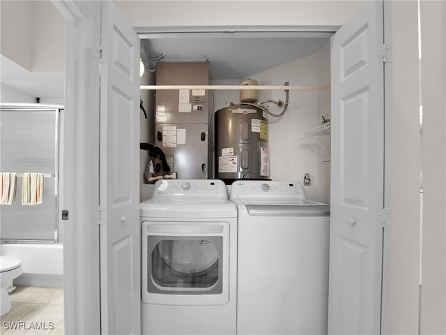 washroom featuring washing machine and dryer, electric water heater, light tile patterned floors, and heating unit