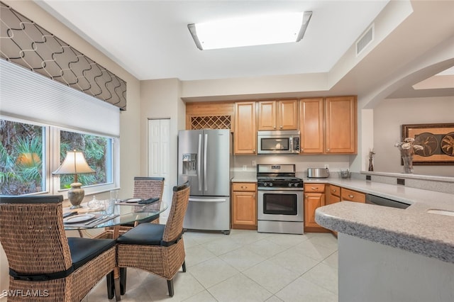 kitchen with stainless steel appliances and light tile patterned flooring