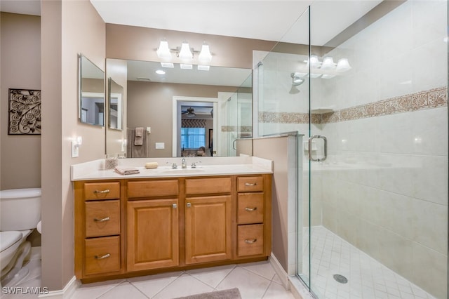 bathroom with toilet, walk in shower, tile patterned floors, vanity, and ceiling fan