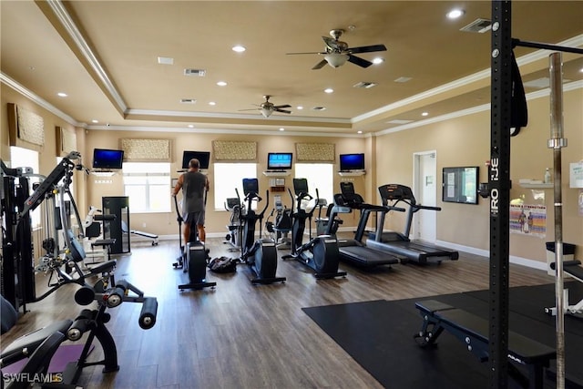 gym featuring hardwood / wood-style flooring, crown molding, and a tray ceiling