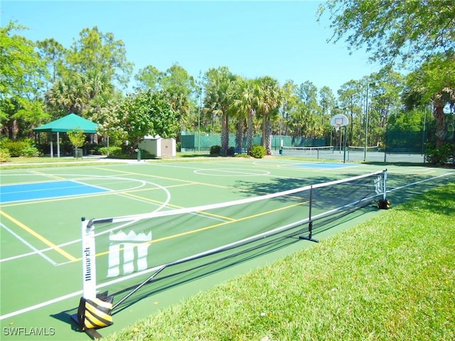 view of sport court featuring a lawn and tennis court