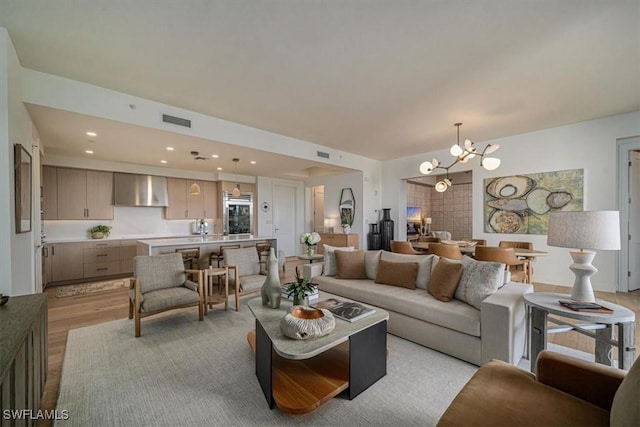 living room with a notable chandelier and light wood-type flooring