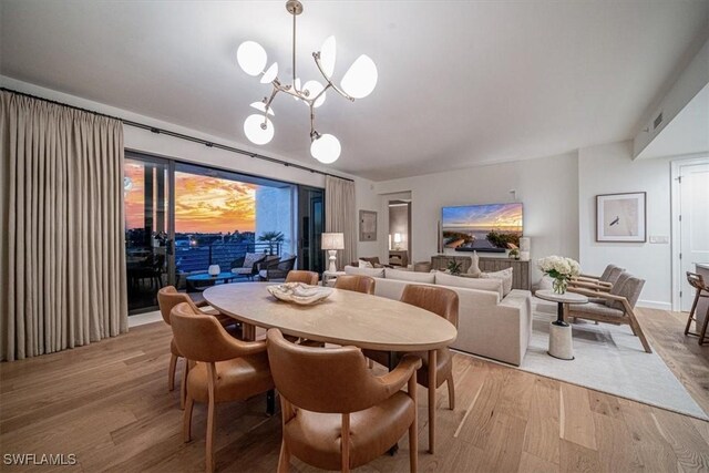 dining space with an inviting chandelier and light wood-type flooring