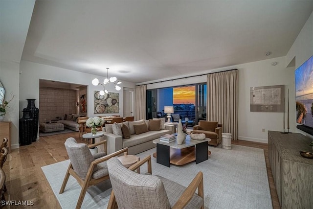 living room with light hardwood / wood-style flooring and an inviting chandelier