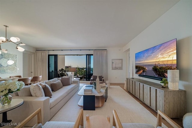 living room with a notable chandelier and light hardwood / wood-style floors