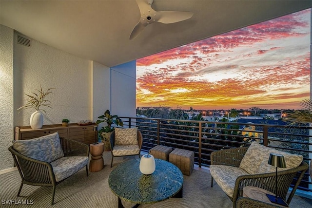 balcony at dusk featuring ceiling fan