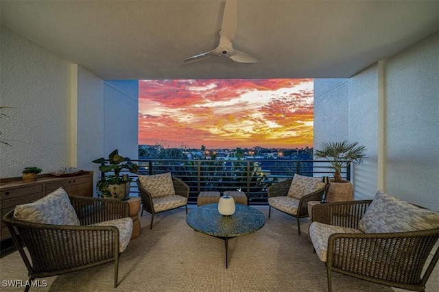 balcony at dusk featuring ceiling fan