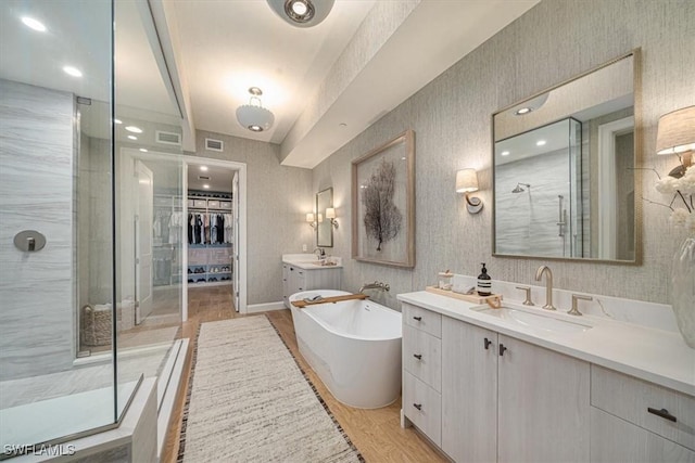 bathroom featuring separate shower and tub, hardwood / wood-style flooring, and vanity