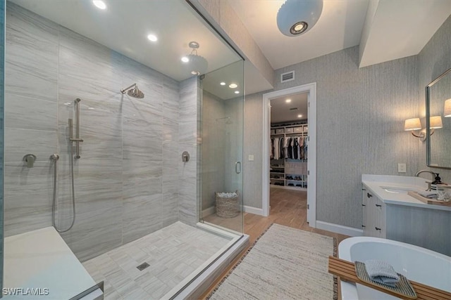 bathroom with hardwood / wood-style flooring, a shower with shower door, and vanity