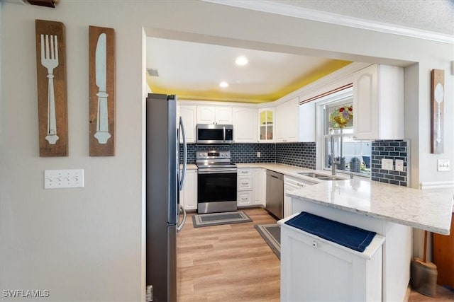 kitchen featuring white cabinetry, sink, hanging light fixtures, kitchen peninsula, and stainless steel appliances