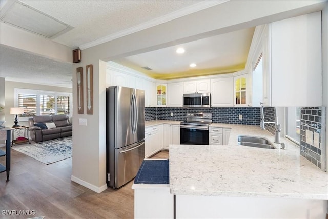 kitchen featuring sink, backsplash, stainless steel appliances, and white cabinets