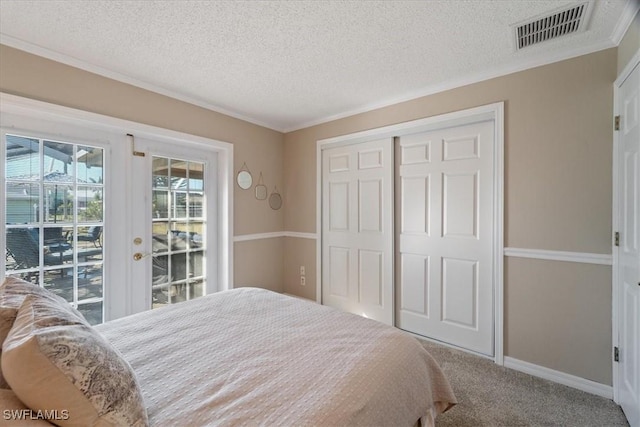 bedroom featuring a closet, access to exterior, carpet, and a textured ceiling