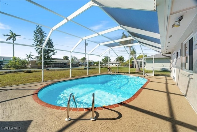 view of swimming pool featuring a patio area, glass enclosure, and a lawn