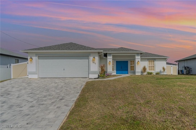 view of front of home with a garage and a yard