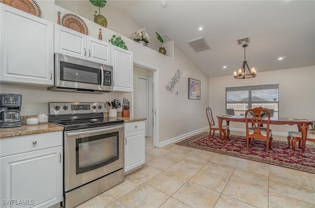 kitchen featuring vaulted ceiling, pendant lighting, white cabinetry, light stone countertops, and appliances with stainless steel finishes